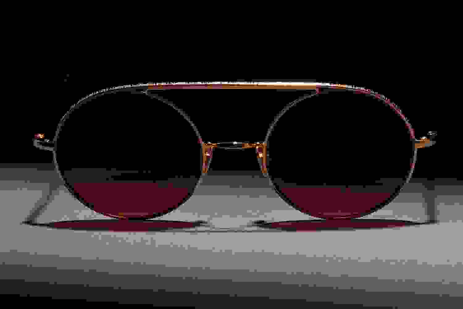 Frontaufnahme von einer Ahlem Brille mit goldenem Rahmen und braunen Brillengläsern.
