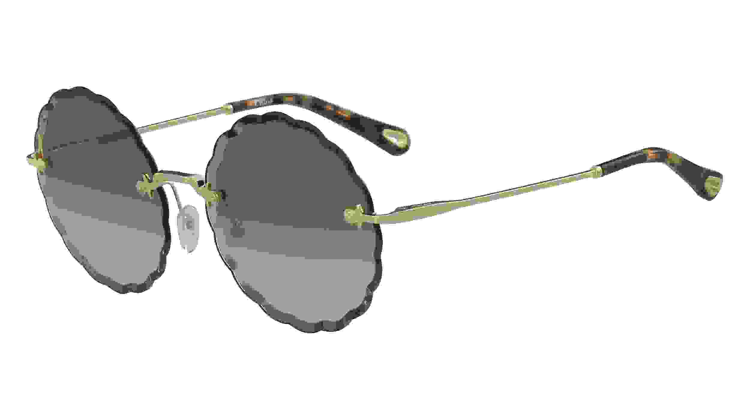Runde Sonnenbrille von Cloé mit dunklen Applikationen am Rahmen, braun getönten Brillengläsern und goldenen Bügeln mit braunen Details am Bügelende.