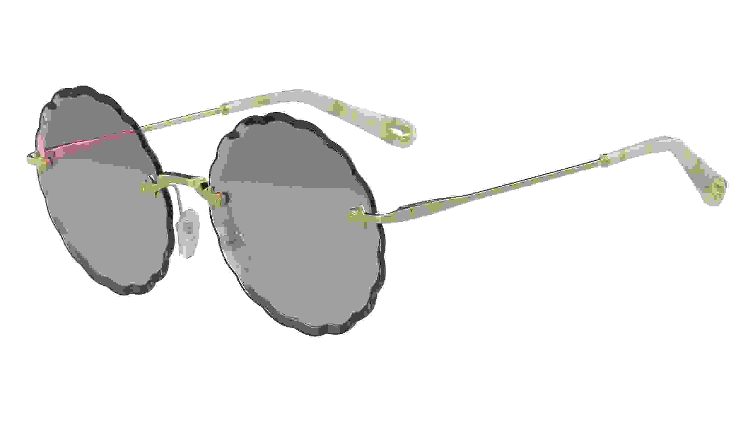 Runde Sonnenbrille von Cloé mit dunklen Applikationen am Rahmen, lila getönten Brillengläsern und goldenen Bügeln.